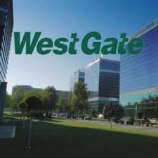 Photograph of big glass buildings with the text "West Gate" in front in green.