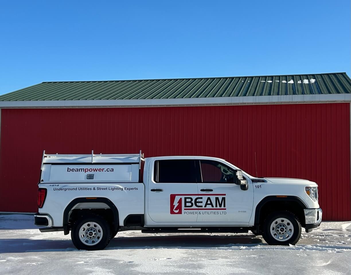 IMG_8681 White Beampower work pickup truck sitting in front of a red building